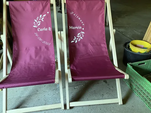 Burgundy deckchairs with a custom wedding design